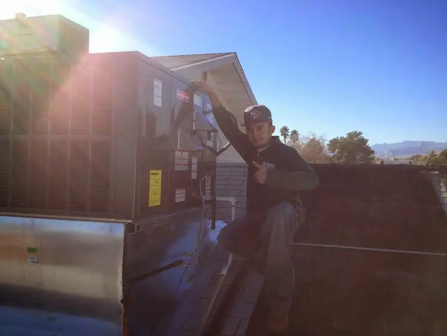 HVAC technician performing AC Tune-Up on a rooftop unit in Green Valley